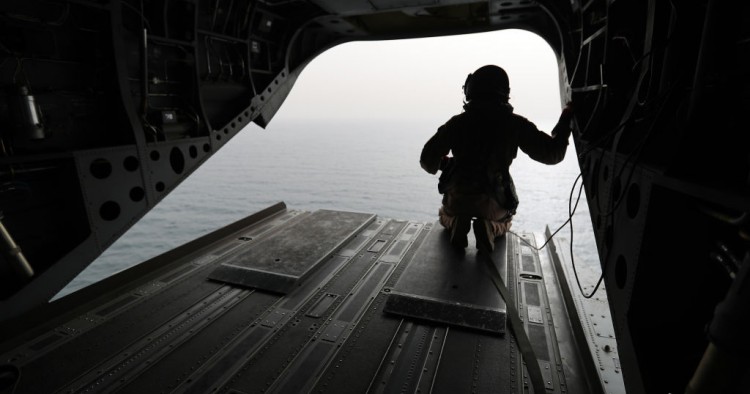 August 2018: An Emirati soldier watching from a military plane a ship crossing through the strategic strait of Bab al-Mandab
