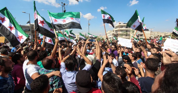  People seen waving flags during the protest against the Syrian regime in Idlib in September 2018.