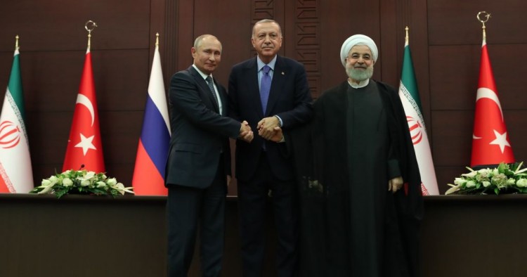 President of Turkey Recep Tayyip Erdogan (C), President of Russia Vladimir Putin (L) and President of Iran Hassan Rouhani (R) shake hands as they pose for a photo after a joint press conference following the Turkey-Russia-Iran trilateral summit at Cankaya Mansion in Ankara, Turkey on September 16, 2019. 