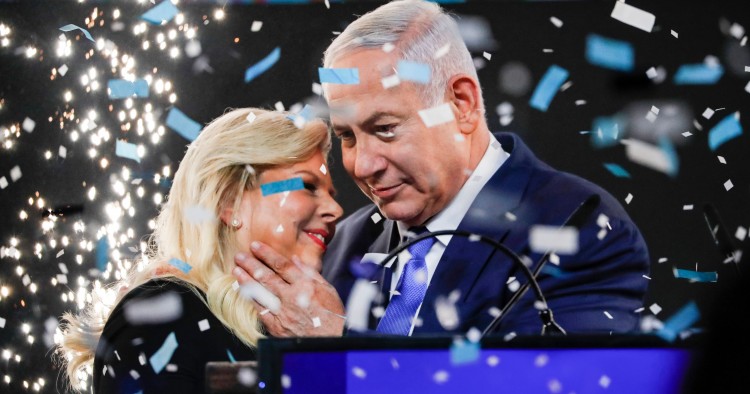 TOPSHOT - Israeli Prime Minister Benjamin Netanyahu embraces his wife Sara as confetti and fireworks are blown during his appearance before supporters at his Likud Party headquarters in the Israeli coastal city of Tel Aviv on election night early on April 10, 2019. (Photo by Thomas COEX / AFP) (Photo credit should read THOMAS COEX/AFP/Getty Images)