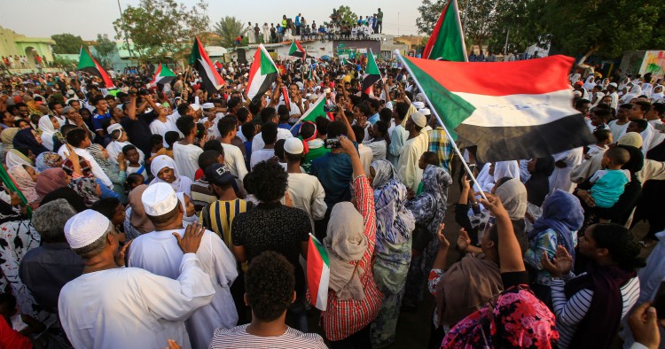 Sudanese people chant slogans and wave national flags as they celebrate after protest leaders struck a deal with the ruling generals on a new governing body, in the capital Khartoum's eastern district of Burri on July 5, 2019, - The deal, reached in the early hours of July 5 after two days of hard-won talks brokered by Ethiopian and African Union mediators, provides for the interim governing body to have a rotating presidency, as a compromise between the positions of the generals and the protesters. The blu