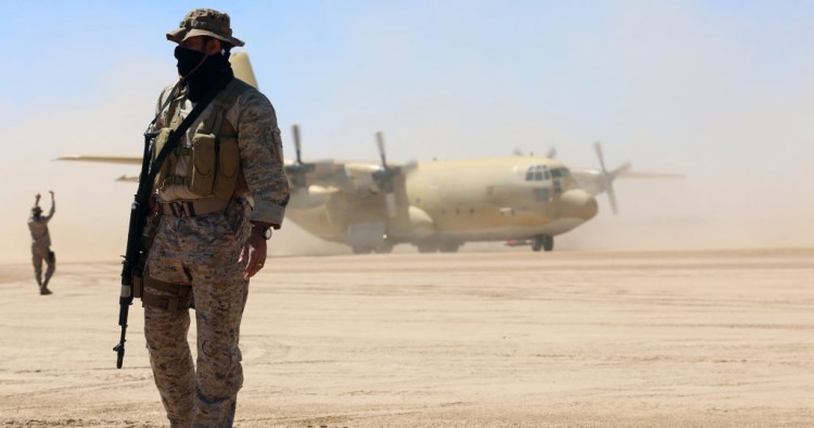 Saudi soldiers stand guard as a Saudi air force cargo plane, carrying aid, lands at an airfield in Yemen's central province of Marib, on February 8, 2018.