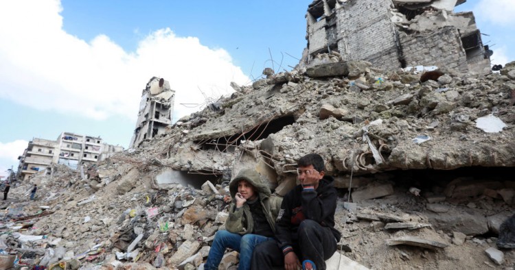 Children sit on the rubble of buildings in Aleppo, Syria.