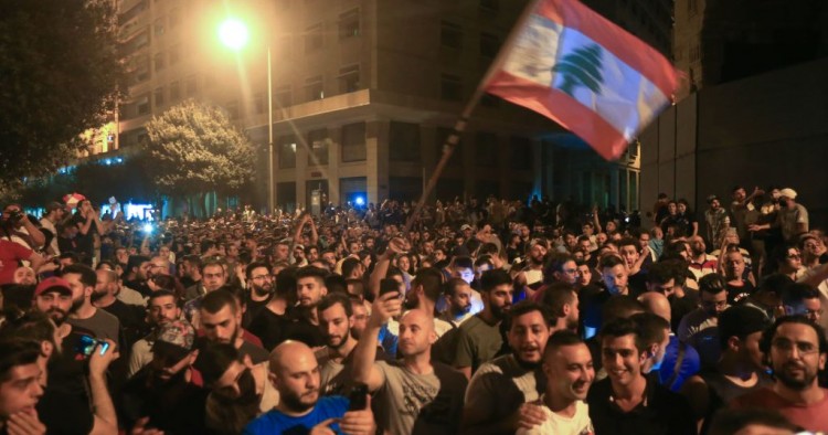 Demonstrators wave a flag during a protest against a government decision to tax calls made on messaging applications on October 17, 2019 outside the government palace in Beirut. 