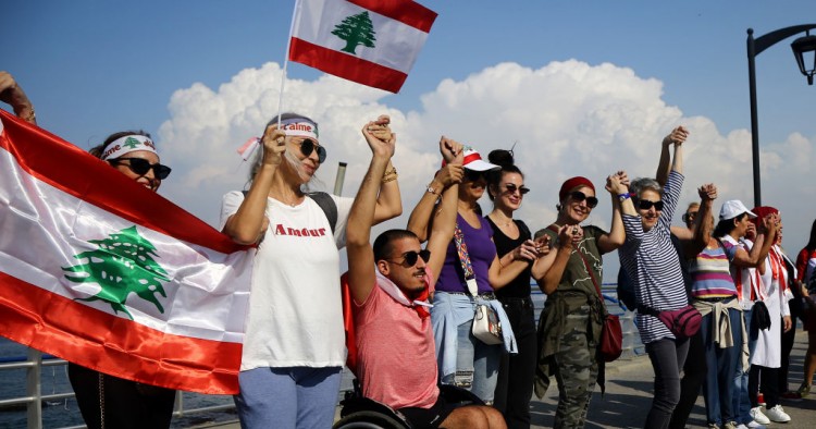 Lebanese people hold hands as they form a human chain, that stretched out along the coast from the capital Beirut to northern and southern Lebanon, symbolizing national unity, on the 11th day of anti-government protests across Lebanon. 