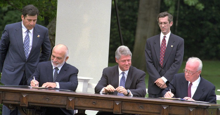 The Israel-Jordan peace treaty being signed in 1994. US President Bill Clinton watches Jordan's King Hussein and Israeli Prime Minister Yitzhak Rabin sign the treaty on the White house lawn