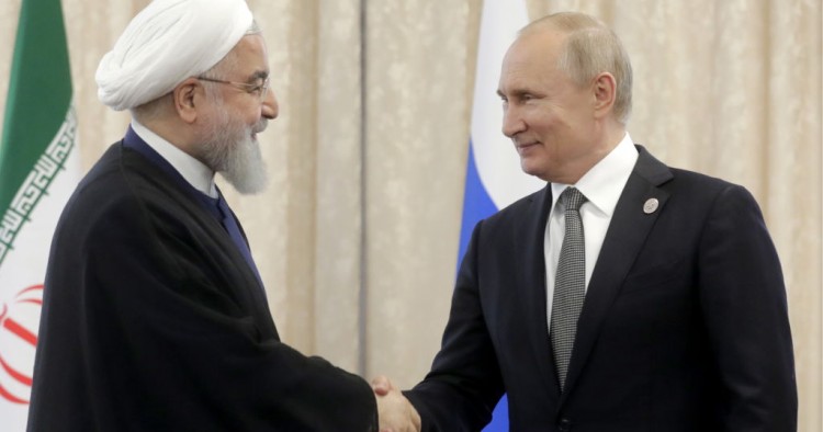 Iran's President Hassan Rouhani (L) and Russia's President Vladimir Putin shake hands as they meet on the sidelines of a meeting of the Shanghai Cooperation Organisation (SCO) Council of Heads of State.