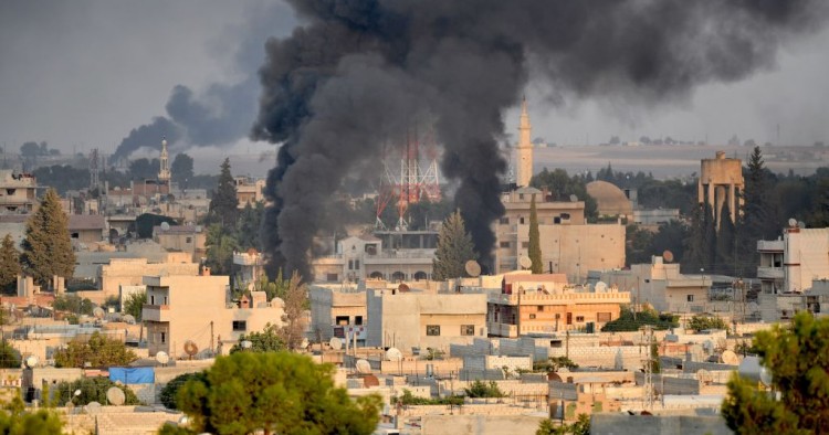 A photo taken from Turkey's Sanliurfa province, on October 09, 2019 shows smoke rises at the site of Ras al-Ayn city of Syria as Turkish troops along with the Syrian National Army begin Operation Peace Spring in northern Syria against PKK/YPG, Daesh terrorists. 