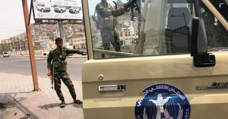 A fighter of the UAE-trained Security Belt Force, dominated by backers of the the Southern Transitional Council (STC) which seeks independence for south Yemen, mans the turret of a technical (pickup truck mounted with an anti-aircraft gun) displaying portraits of separatist leader Aidarus al-Zubaidi and showing the logo of the STC, in the Crater district in the centre of Yemen's second city of Aden on August 12, 2019.