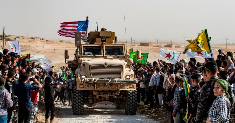  Syrian Kurds gather around a US armoured vehicle during a demonstration against Turkish threats next to a US-led international coalition base on the outskirts of Ras al-Ain town in Syria's Hasakeh province near the Turkish border on October 6, 2019. 