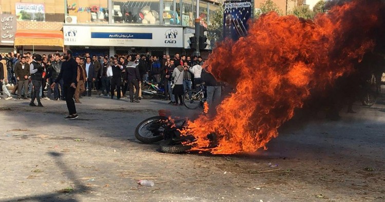 Iranian protesters gather around a burning motorcycle during a demonstration against an increase in gasoline prices in the central city of Isfahan, on November 16, 2019.