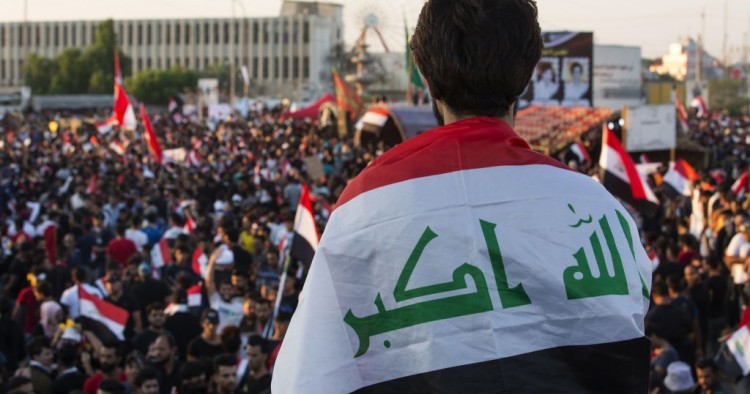 An Iraqi protester deaped in his national flag takes part in an anti-government protest in the southern city of Basra on November 1, 2019.