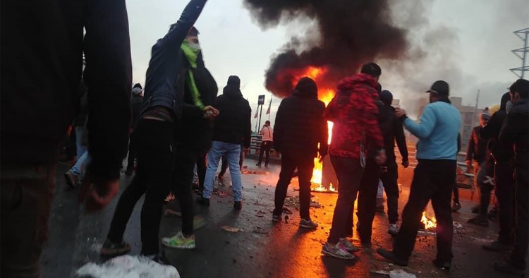 Iranian protesters gather around a fire during a demonstration against an increase in gasoline prices in the capital Tehran, on November 16, 2019. - One person was killed and others injured in protests across Iran, hours after a surprise decision to increase petrol prices by 50 percent for the first 60 litres and 300 percent for anything above that each month, and impose rationing. Authorities said the move was aimed at helping needy citizens, and expected to generate 300 trillion rials ($2.55 billion) per 