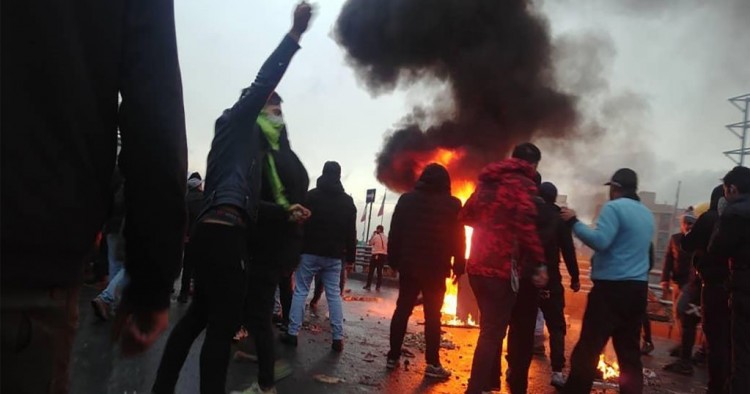 Iranian protesters gather around a fire during a demonstration against an increase in gasoline prices in the capital Tehran, on November 16, 2019. 