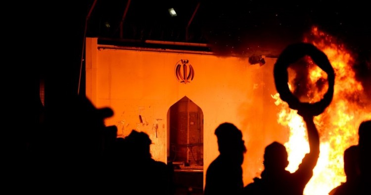 Iraqi demonstrators gather as flames start consuming Iran's consulate in the southern Iraqi Shiite holy city of Najaf on November 27, 2019, two months into the country's most serious social crisis in decades.