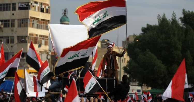 Iraqi demonstrators wave national flags as they take part in an anti-government demonstration in the capital Baghdad's Tahrir Square, on December 6, 2019. 