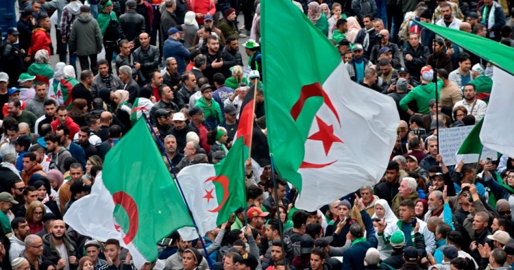 Algerian protesters wave national flags during an anti-government demonstration in the capital Algiers, on December 20, 2019. 