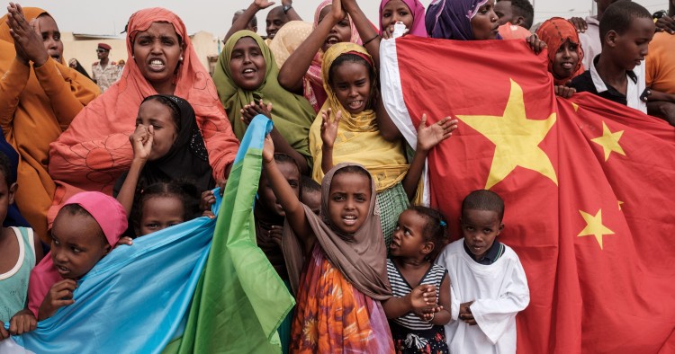 People hold Chinese and Djiboutian national flags as they wait for the arrival of Djibouti's President Ismail Omar Guellehas before the launching ceremony of new 1000-unit housing contruction project in Djibouti, on July 4, 2018. - The new 1000-unit construction project by the Ismail Omar Guelleh Foundation for Housing is financially supported by China Merchant, the operation parther of newly inaugurated Djibouti International Free Trade Zone (DITTZ) with Djibouti Ports and Free Zones Authority, to build ba