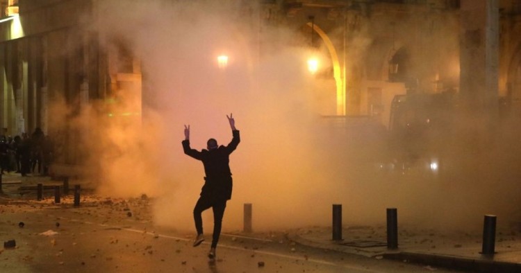 A Lebanese protester gestures at riot police guarding a road leading to parliament in central Beirut on January 19, 2020 amid ongoing anti-government demonstrations. (Photo by PATRICK BAZ / AFP) (Photo by PATRICK BAZ/AFP via Getty Images)