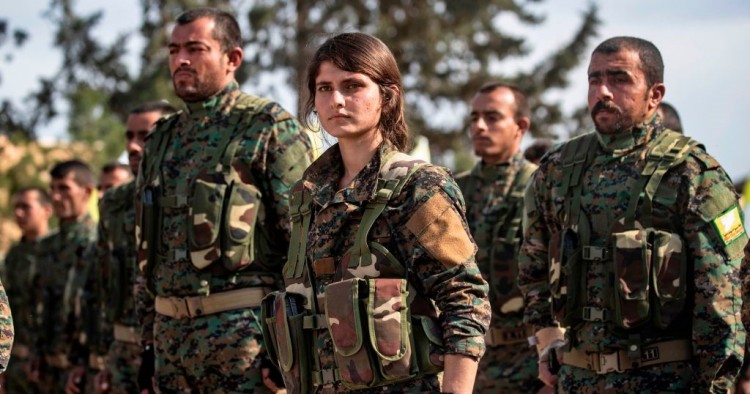 Fighters of the US-backed Kurdish-led Syrian Democratic Forces (SDF) take part in a parade to celebrate near the Omar oil field in the eastern Syrian Deir Ezzor province on March 23, 2019, after announcing the total elimination of the Islamic State (IS) group's last bastion in eastern Syria. 