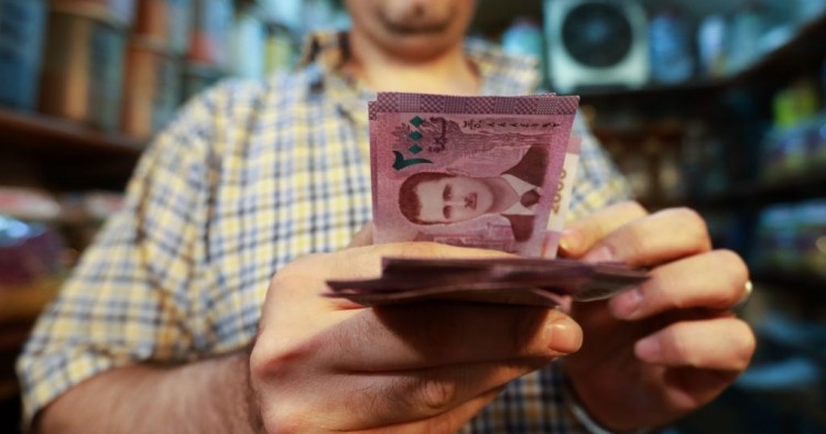 A merchant counts Syrian pound notes, bearing a portrait of the Syrian President Bashar al-Assad, at the Bzourieh market in the centre of the Syrian capital Damascus on September 11, 2019. 