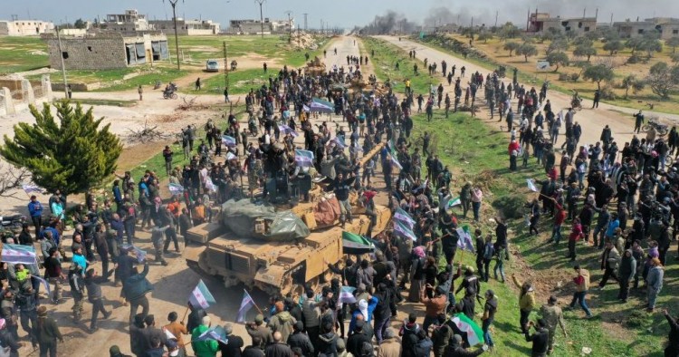 Syrians in protest climb atop a Turkish military M60T tank and infantry-fighting vehicle (IFV) as they attempt to block traffic on the M4 highway, which links the northern Syrian provinces of Aleppo and Latakia, before incoming joint Turkish and Russian military patrols (as per an earlier agreed upon ceasefire deal) in the village of al-Nayrab, about 14 kilometres southeast of the city of Idlib and seven kilometres west of Saraqib in northwestern Syria on March 15, 2020