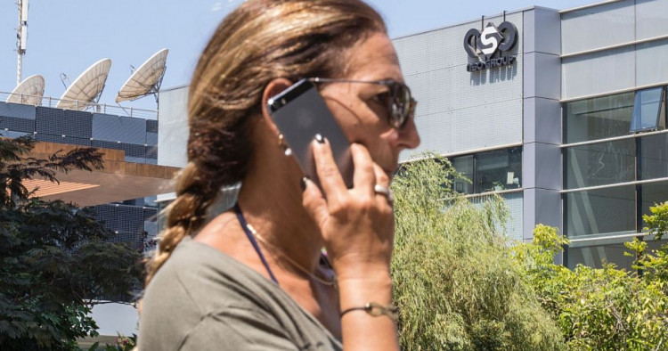 An Israeli woman uses her iPhone in front of the building housing the Israeli NSO group, on August 28, 2016, in Herzliya, near Tel Aviv. 