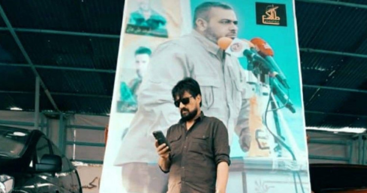 National Defense Commander Abdel Qader Hamo and behind him a picture of Ali Al-Yasiri, the leader of the concrete 