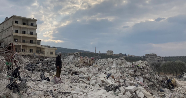 Cover photo: A man watches on as a family sifts through their destroyed home looking for blankets and clothes. Photo by Gregory Waters.