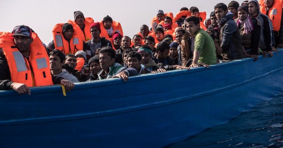 Migrants and refugees are assisted by members of the Spanish NGO Proactiva Open Arms as they crowd on board of a wooden boat sailing out of control at 20 miles (38 km) north of Sabratha, Libya on February 18, 2017.