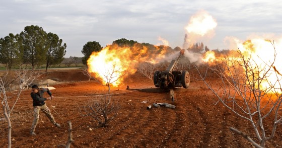 An opposition fighter fires a gun from a village near al-Tamanah during ongoing battles with government forces in Syria's Idlib province on January 11, 2018