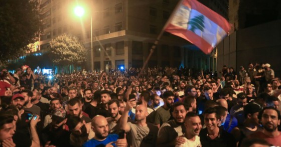 Demonstrators wave a flag during a protest against a government decision to tax calls made on messaging applications on October 17, 2019 outside the government palace in Beirut.
