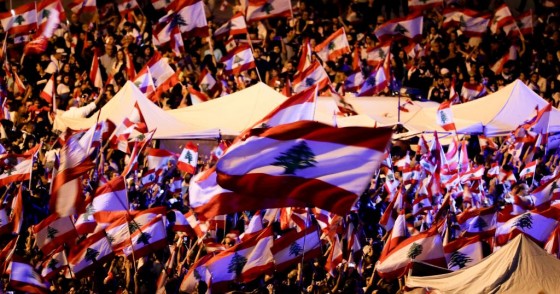 Lebanese anti-government protesters wave national flags as they take part in an anti-govenment demonstration in the capital Beirut's downtown district on November 3, 2019.