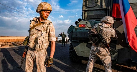 TOPSHOT - Russian military police members stand outside an armoured personnel carrier (APC) along a road in the countryside near the northeastern Syrian town of Amuda in Hasakeh province on October 24, 2019, as part of a joint patrol between Russian forces and Syrian Kurdish Asayish internal security forces near the border with Turkey. - Russian forces have started patrols along the flashpoint frontier, filling the vacuum left by a US troop withdrawal that effectively returned a third of the country to the