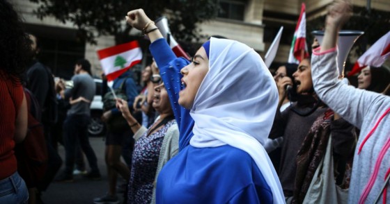 Lebanese anti-government protesters shout slogans as they march on the former demarcation line separating Beirut on December 1, 2019. 