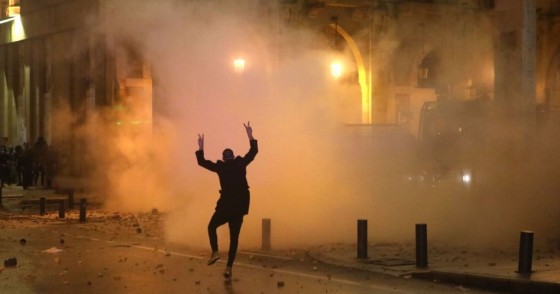 A Lebanese protester gestures at riot police guarding a road leading to parliament in central Beirut on January 19, 2020 amid ongoing anti-government demonstrations. (Photo by PATRICK BAZ / AFP) (Photo by PATRICK BAZ/AFP via Getty Images)