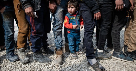 Displaced Syrians wait in a queue as an NGO delivers bread as they wait to receive humanitarian aid in a stadium which has been turned into a makeshift refugee shelter on February 19, 2020 in Idlib, Syria.