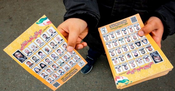 A man standing outside a mosque in the Iranian capital Tehran on February 14, 2020 hands out electoral leaflets showing candidates campaigning in the upcoming Iranian legislative election due to take place on February 21. (Photo by -/AFP via Getty Images)