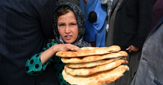 Young Afghan girl holding bread. 