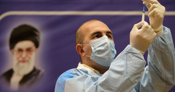 An Iranian medical personnel fills a syringe with the Russian Sputnik-V vaccine, The first registered vaccine against COVID-19, while standing next to a portrait of Irans Supreme Leader Ayatollah Ali Khamenei during a ceremony of initiation of general vaccination against the new coronavirus disease, in a hospital in western Tehran on February 9, 2021. (Photo by Morteza Nikoubazl/NurPhoto via Getty Images)