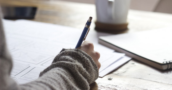 A student writes in a notebook