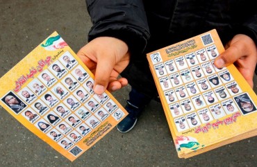 A man standing outside a mosque in the Iranian capital Tehran on February 14, 2020 hands out electoral leaflets showing candidates campaigning in the upcoming Iranian legislative election due to take place on February 21. (Photo by -/AFP via Getty Images)