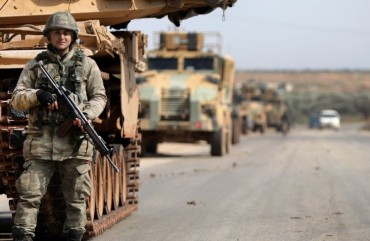 A Turkish soldier stands in front of a military vehicles convoy east of Idlib city in northwestern Syria on February 20, 2020 amid ongoing regime offensive on the last major rebel bastion in the country's northwest. 
