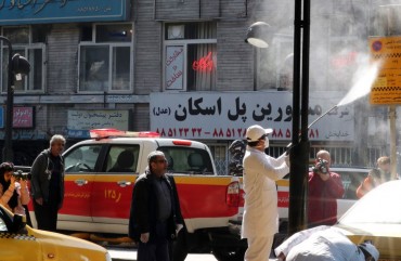Iranian fire fighters and municipality workers disinfect a street in the capital Tehran for corona virus COVID-19 on March 5, 2020. 