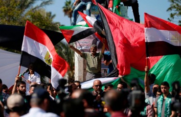 A man waves a Palestinian flag while protesting. 