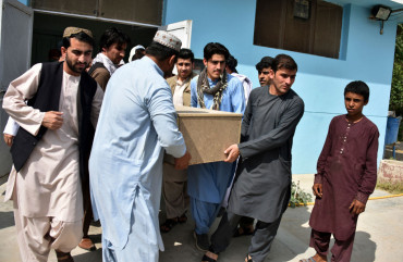 Relatives carry a coffin with the body of television journalist Nemat Rawan after he was shot dead by gunmen, in Kandahar Provicne on May 6, 2021.