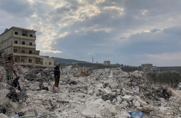 Cover photo: A man watches on as a family sifts through their destroyed home looking for blankets and clothes. Photo by Gregory Waters.