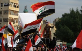 Iraqi demonstrators wave national flags as they take part in an anti-government demonstration in the capital Baghdad's Tahrir Square, on December 6, 2019. 