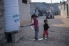 A young Palestinian draws water from a tank